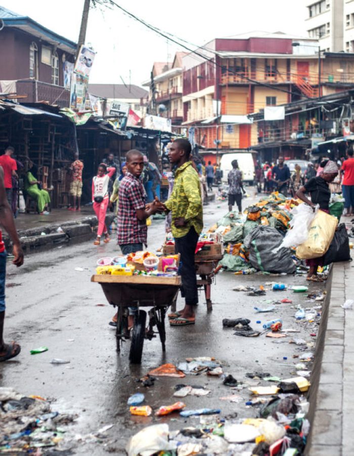 Lagos, Nigeria: Two men greeting each other in market street in Lagos Island district.